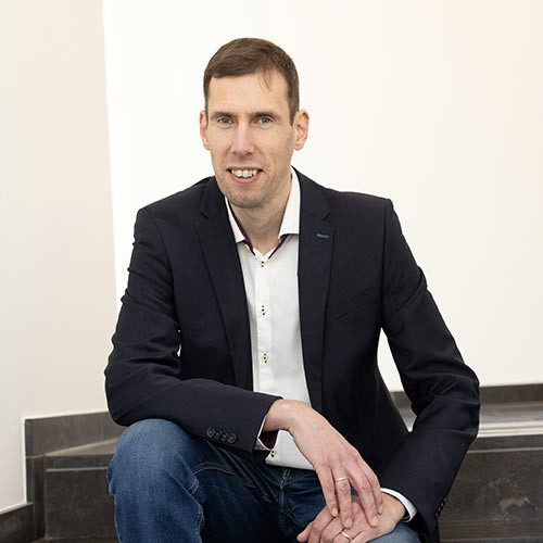 Man in blazer sitting indoors
